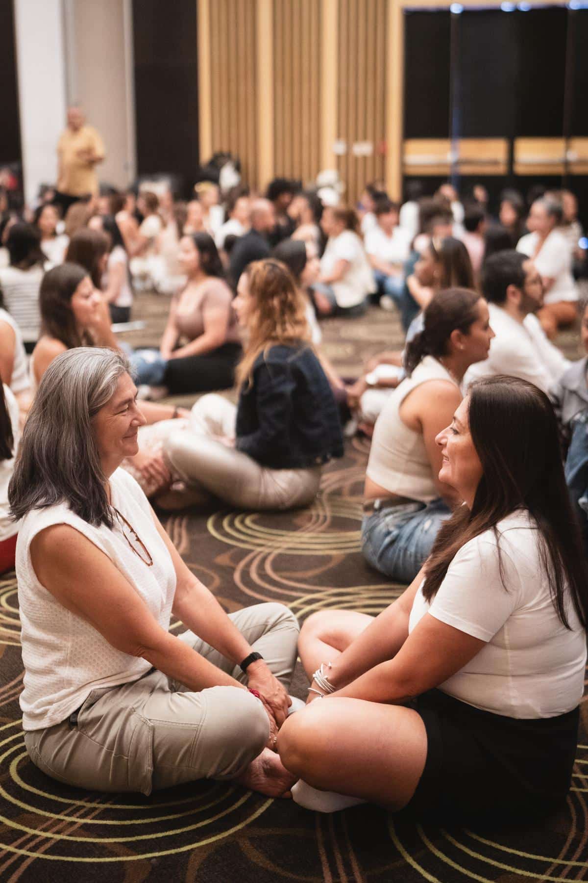 Participantes sentadas en el suelo, en círculo, conversando