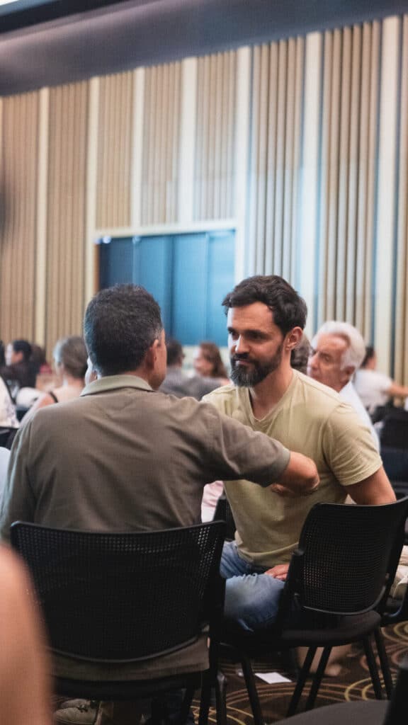 Dos participantes conversan frente a frente durante un ejercicio en parejas en una jornada de bienestar