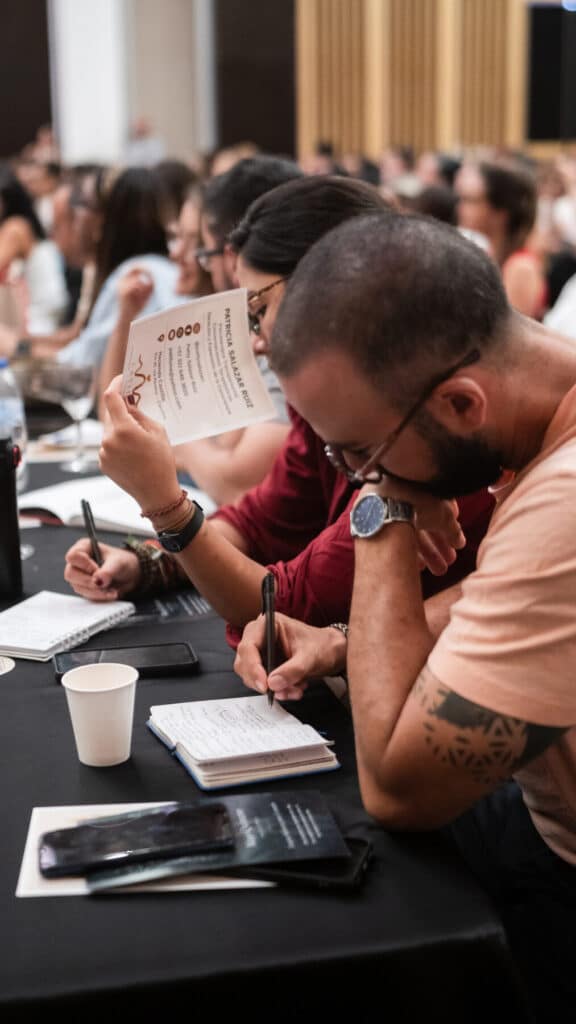 Participantes escriben en sus cuadernos durante un taller vivencial