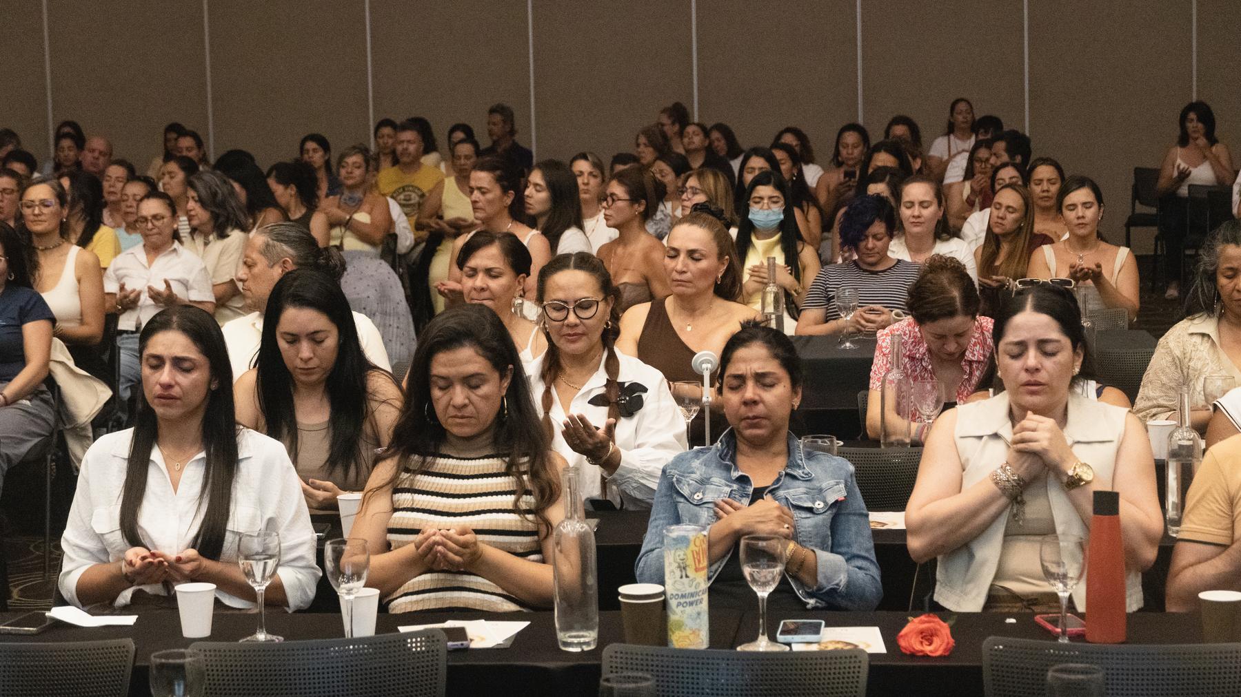 Cientos de personas reunidas en el auditorio de Vibra Fest con los ojos cerrados